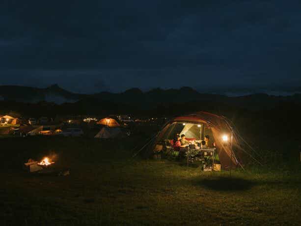 テントの中で夜中のキャンプ楽しむ家族