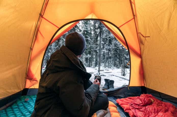 テントの中から雪が降る外を眺める