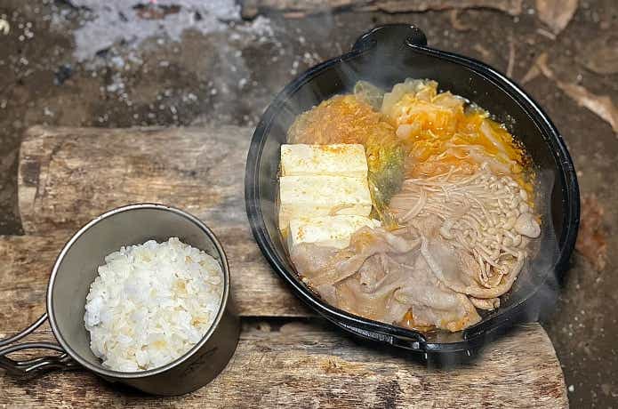 南部鉄器の鉄鍋で調理されたキムチ鍋とチタンマグで炊飯されたご飯