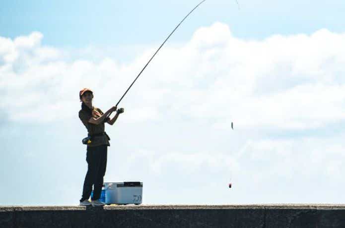 釣りをする女性とダイワのクーラーボックス