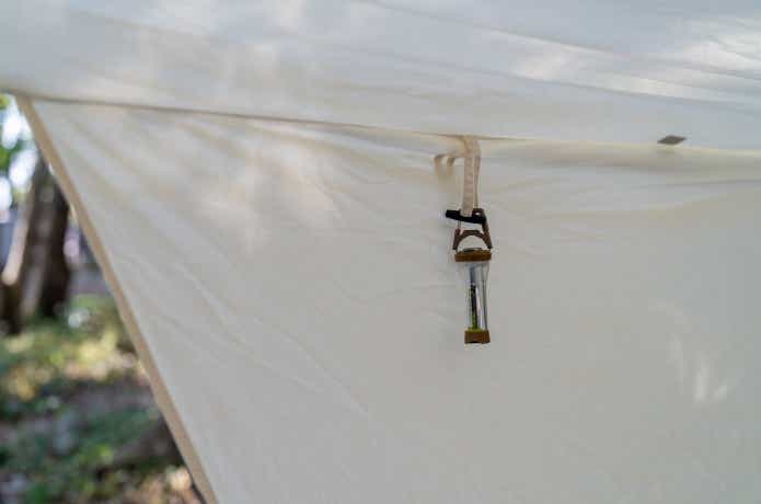 アソマタスのエクスゲートを装着したライトハウスマイクロフラッシュをテントのフラップに吊り下げる
