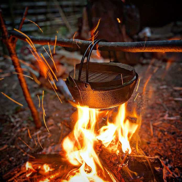 焚き火で加熱中の鉄鍋