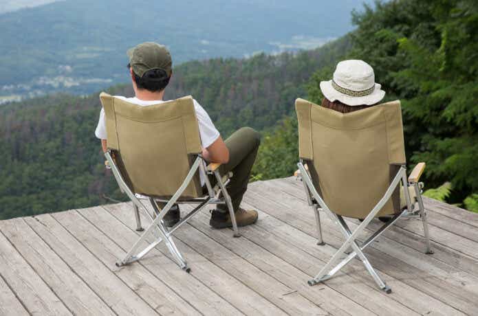 キャンプ椅子に座って景色を見ている夫婦