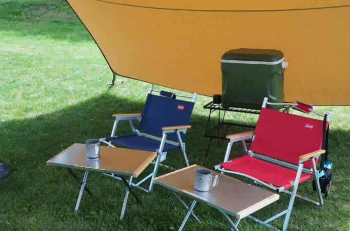 折りたたみ式のキャンプ椅子がタープの下に置かれている