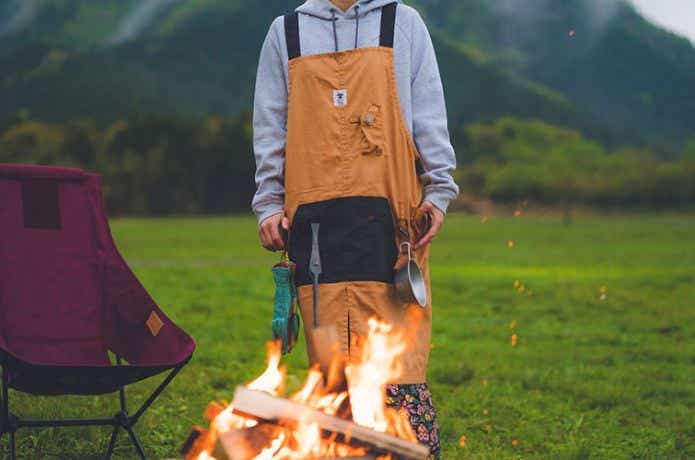 キャンプ用エプロンを着て焚き火