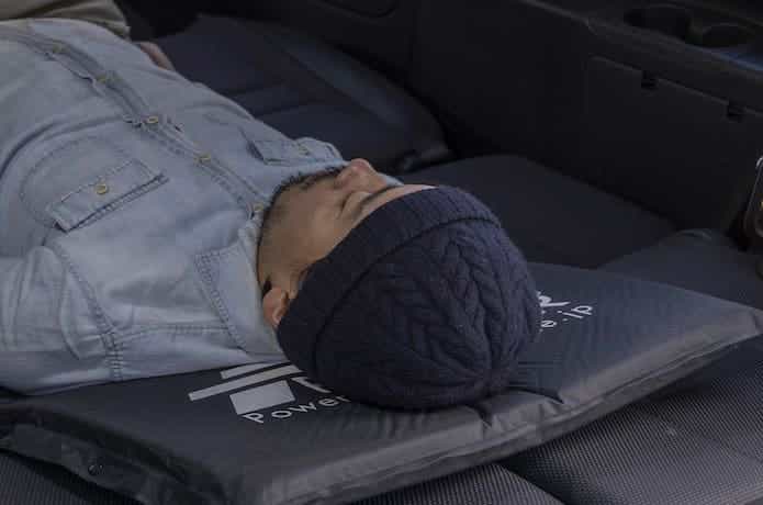 車中泊用マットに男性が寝ている