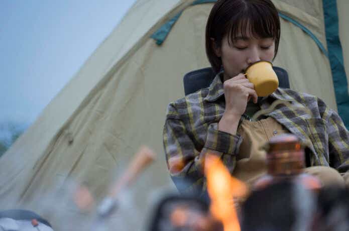 ソロキャンプで焚き火を楽しむ女性