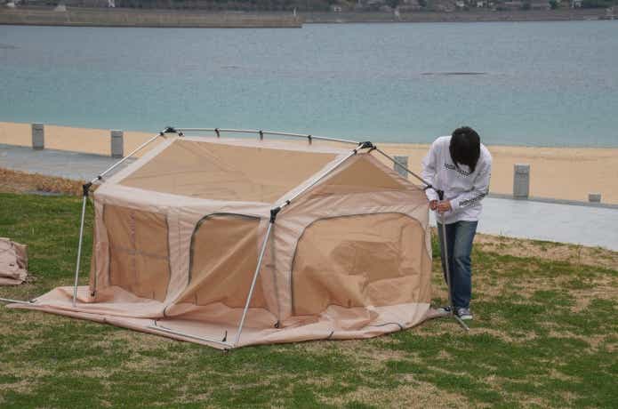A型テントを設営する人