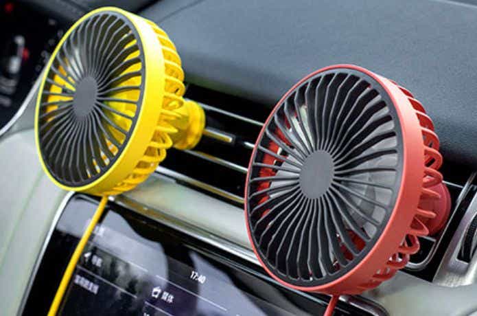 エアコンの送風口に赤と黄色の車中泊用扇風機をつける