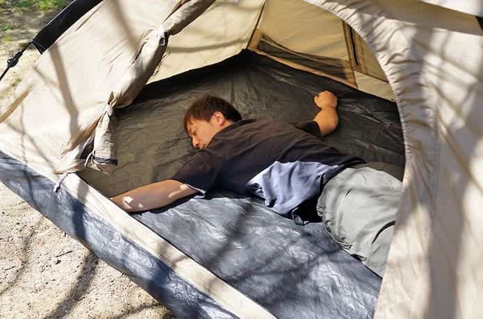 DOD「ワンタッチテント」に腕を広げた状態で寝ている男性