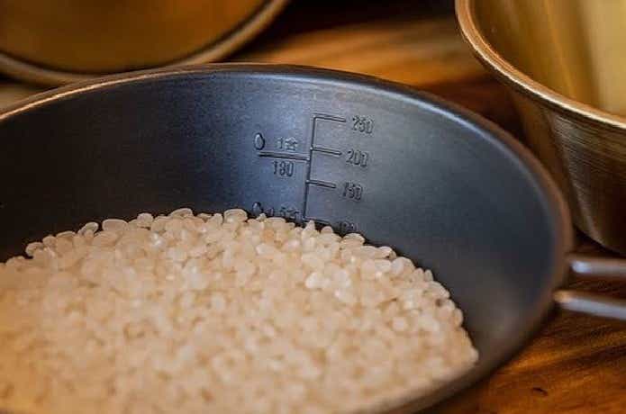 シェラカップで米の量を測っている様子