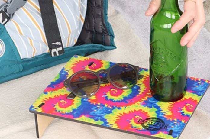 カラフルなテーブルの上に瓶とサングラスを置く