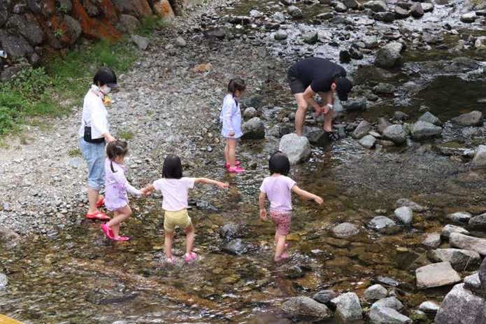 みつえ青少年旅行村で川遊びをする家族