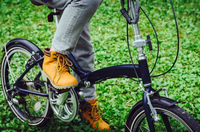 黒い折り畳み自転車に乗る