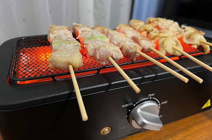 この夏は暑すぎて、とても屋外でBBQなどする気になりません。だけど、冷たいビールを片手に出来立てアツアツの焼き鳥をほおばりたい。できればエアコンの効いた涼しいリビングで…。現実には“煙問題”が大きく立ちはだかり、あきらめかけていた筆者。ですが最近、YAMAZEN「減煙電気七輪」を発見！はたして理想通りの宅飲みが実現するのか、詳しくレビューします。