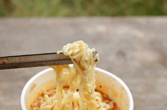 箸トングチタンでカップラーメンの麺を掴んでいる