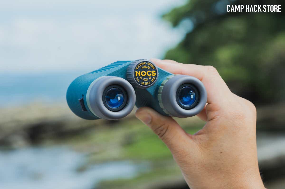 NOCSの「STANDARD ISSUE 8x25 WP BINOCULARS」を手に持つ