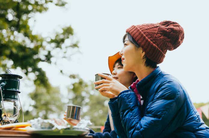 防寒着を着てドリンクを飲む女性