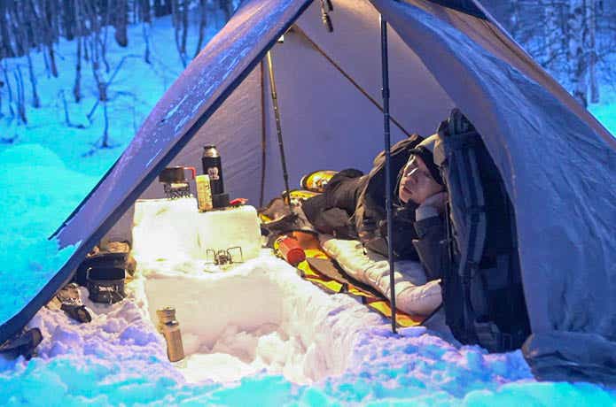 雪中キャンプをする男性