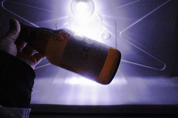 クーラーライトの明かりで飲料ラベルを見分けている