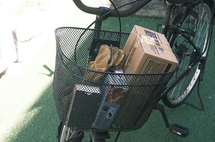 自転車かごに入ったダイソーの薪