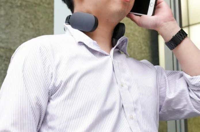 ネッククーラーをつけて電話をする男性