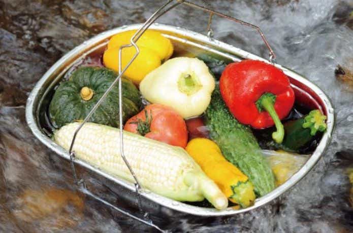 ユニフレーム フィールドキャリングシンクに野菜を入れて川に入れる