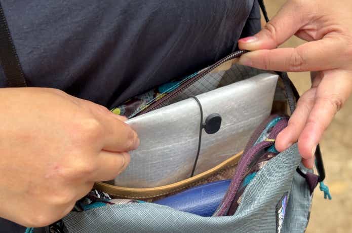 ペルクラを折りたたんでサコッシュに入れている