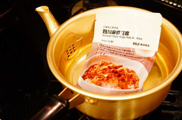 やかん鍋でレトルトパウチを温めている様子
