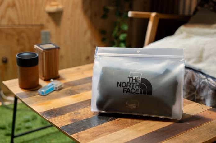 「ノースフェイス」パックTポーチがギアと共にテーブルに置かれている