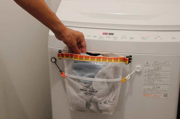 ボタンスリング2個使いで洗濯機にカゴを吊るしている