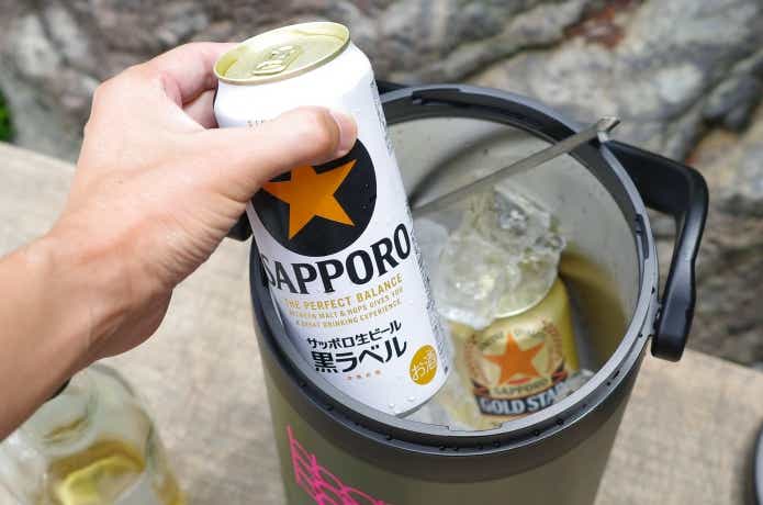 アウトドアアイスストレージからビールを取り出している