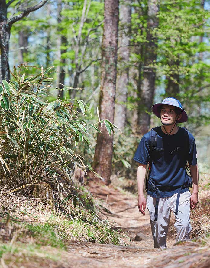 ベイシントゥーガーデンショートスリーブTシャツを着て登山する男性