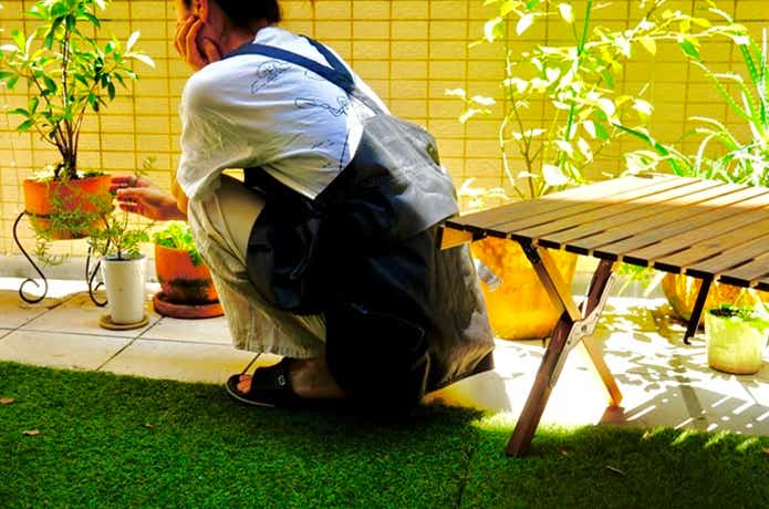 無印良品アウトドアエプロンを着用してしゃがむ女性