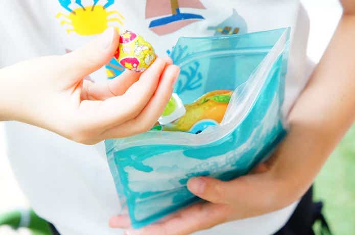 ラコレのアイスパックにお菓子を入れて持つ子供の手