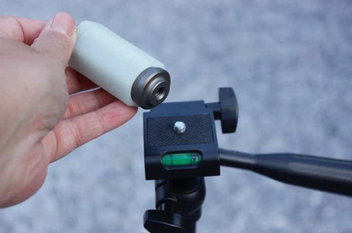 カメラ三脚のネジ穴にキャンプライフマルチフックをセットするところ