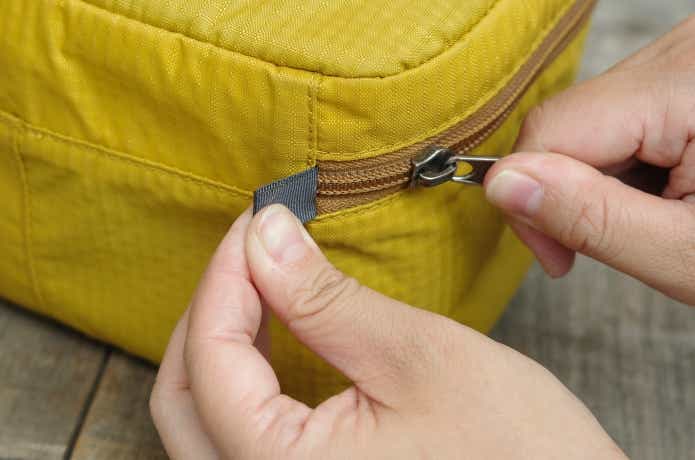 ループを指で押さえてジッパーを締めるところ