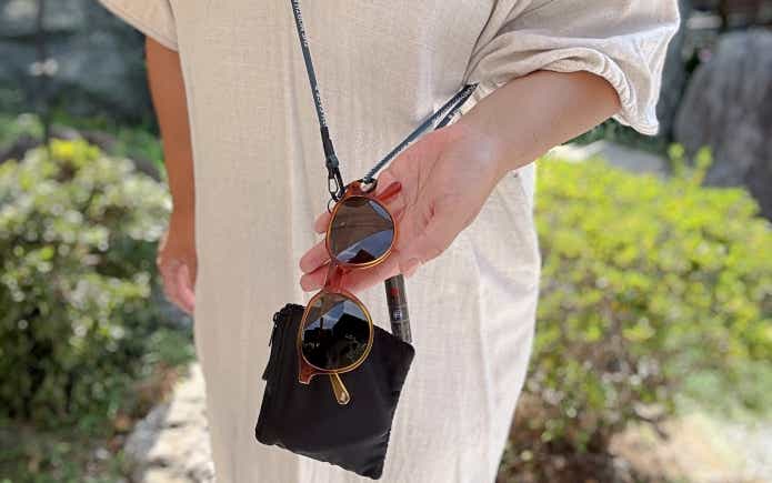 アイビーマルチパーパスランヤードに小銭入れ、リップクリーム、サングラスをかけている