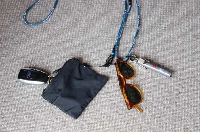 アイビーマルチパーパスランヤードに小銭入れ、リップクリーム、サングラスをかけている