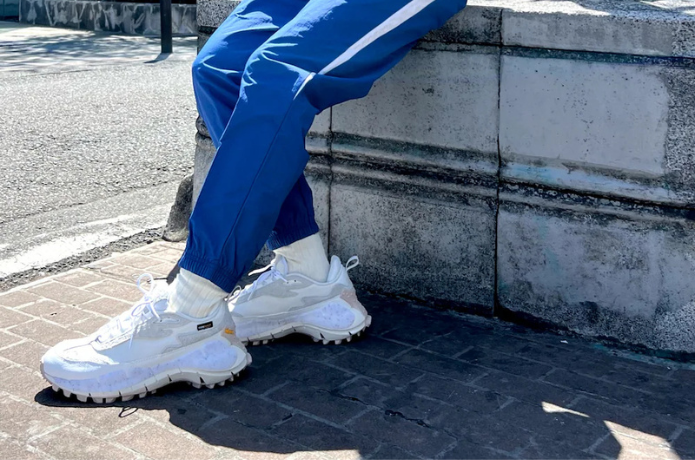 リーボックの白いランニングシューズを履いた人