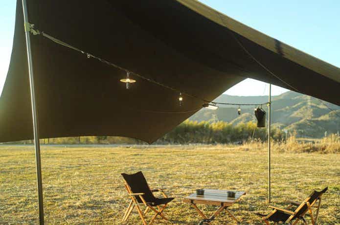 タープの下でハンギングチェーンでLEDランタンを吊るす