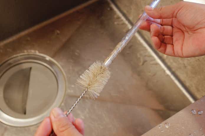 ストローをブラシで洗っているところ