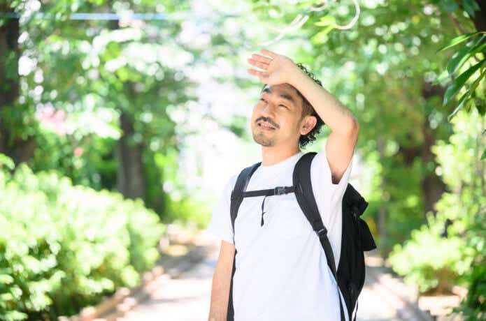 リュックを背負って暑そうにしている男性