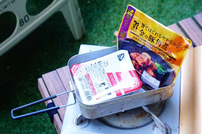 メスティンにお湯をはり、湯煎でれとるとごはんと金の豚角煮を温めている様子