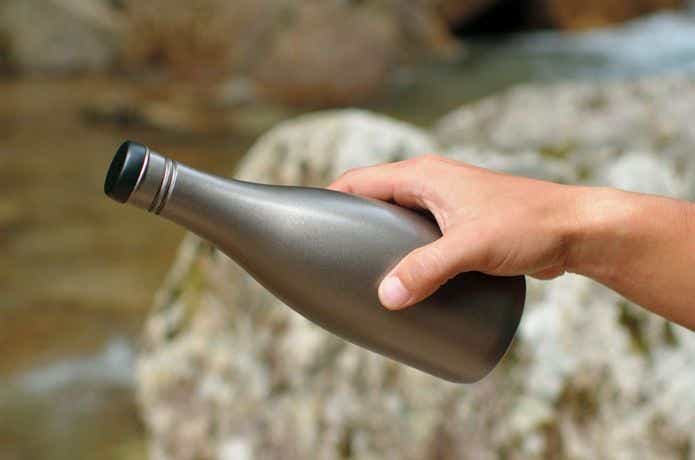 スノーピークの酒グッズをもつ