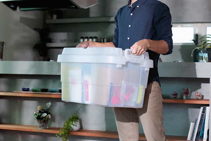 クリアカラーのトランクカーゴを運ぶ男性