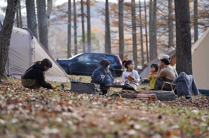 キャンプサイトに座るファミリー
