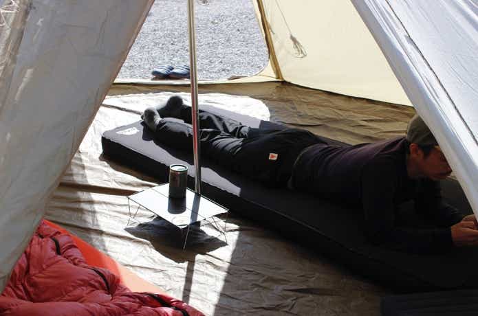 砂利の上でマットに寝転んでいる