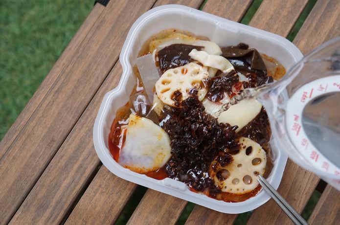 海底撈（カイテイロウ）の麻辣火鍋の具材に水を注ぐ