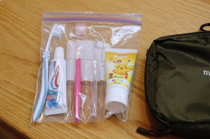 ジッパーバッグに家族分の歯ブラシと歯磨き粉が入っている